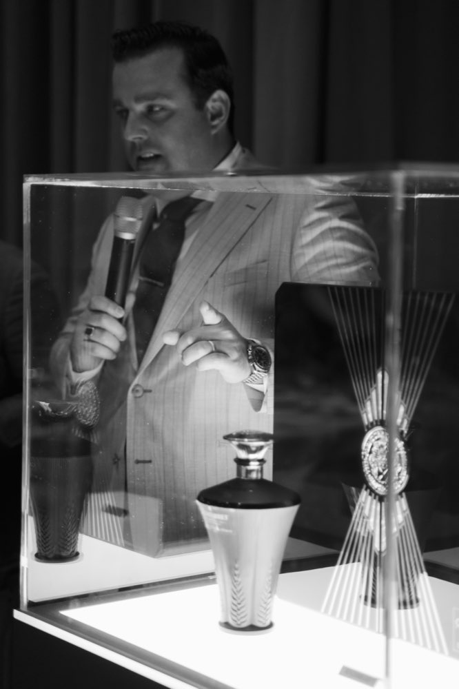 Black and white photo of a man speaking with a microphone at the Exceptionals Cup event